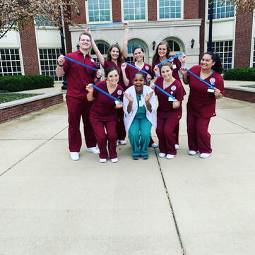 Dr. Scott and clinical students in front of College of Nursing